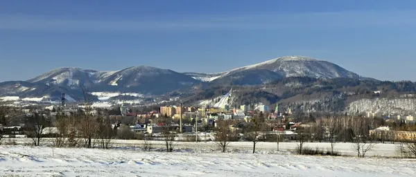 Zasněžený Frenštát se skokanskými můstky pod hřebeny Beskyd