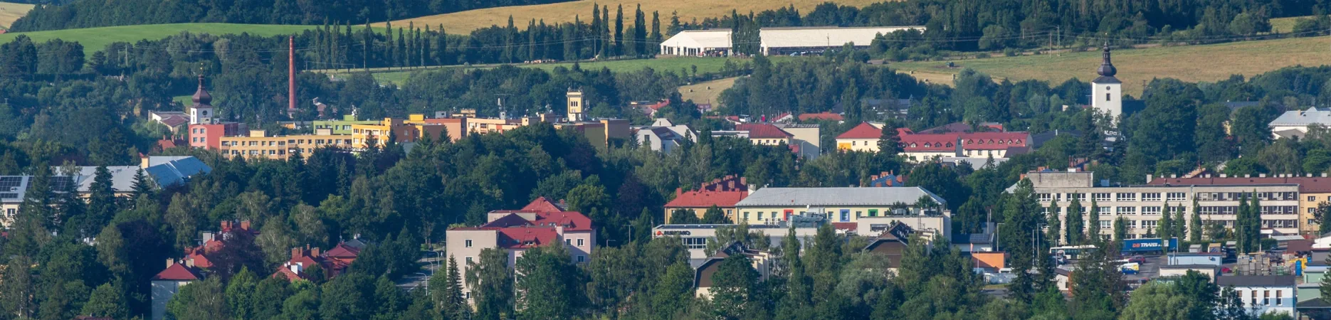 Panorama Frenštátu s velkou průmyslovou halou na okraji města v pozadí